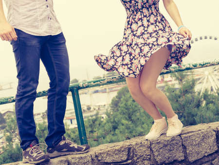 Unrecogniazble man and woman having romantic date looking wearing fashionable outfits. Guy wearing jeans and white shirt, woman floral short summer dress.の写真素材
