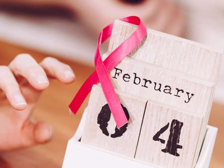 Old fashioned calendar with 4 february world breast cancer day, date with pink awareness ribbon....