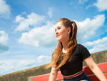 Happy joyful smiling woman spending her free time outside enjoying beautiful summertime weather.