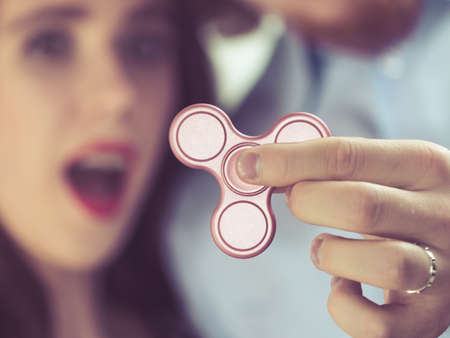 Woman being fascinated by pink fidget spinner. Social media trend, funny toy concept.の写真素材