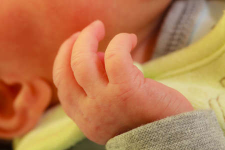 Childhood, infant care, parenting, body details concept. Little newborn baby hand closeup.