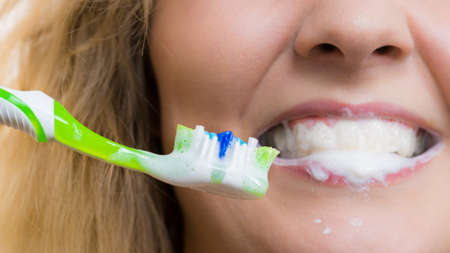 Woman brushing cleaning teeth. Positive girl with toothbrush. Oral hygiene.の写真素材