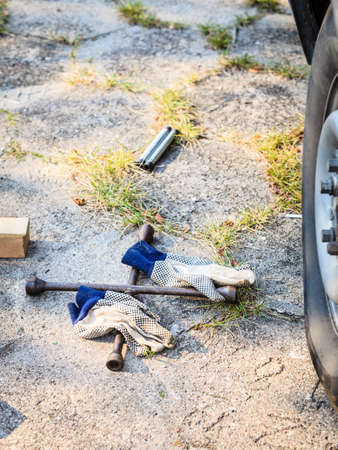 Manual socket wheel wrench and jack lying on ground. Tire car repair objects concept.