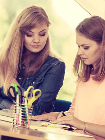 Two students sitting in class planning concept, studying together creating new startup enjoying...