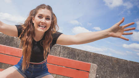 Happy joyful smiling woman spending her free time outside enjoying beautiful summertime weather.の写真素材
