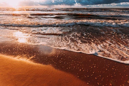 Amazing colorful sunset over evening sea horizon, clouds sky and sandy beach. Tranquil scene. Natural background. Landscape.の写真素材