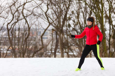 Outdoor sport exercises, sporty outfit ideas. Woman wearing warm sportswear training exercising outside during winter.の写真素材