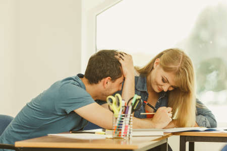 Two students sitting in class planning concept, studying together creating new startup enjoying their work time.の写真素材