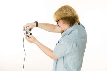 Nerd geek young adult man playing on the video console holding game pad. Gaming gamers concept.