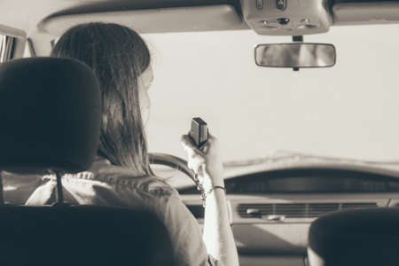 Talking while drive, auto walkie talkie, comunication concept. Young man driving car using cb radio. Black and white photo.の写真素材