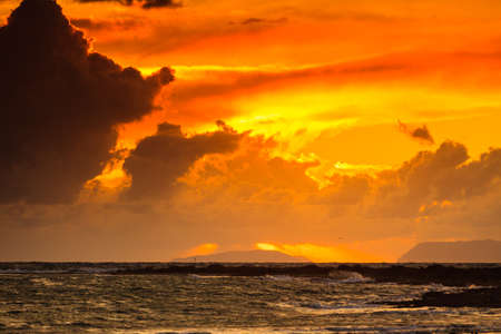 Dramatic sunset over sea surface with dark stormy clouds, Greece Peloponnese.の写真素材