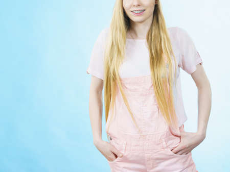 Happy cheerful teenage young woman ready for summer wearing pink outfit and sun hat.の写真素材