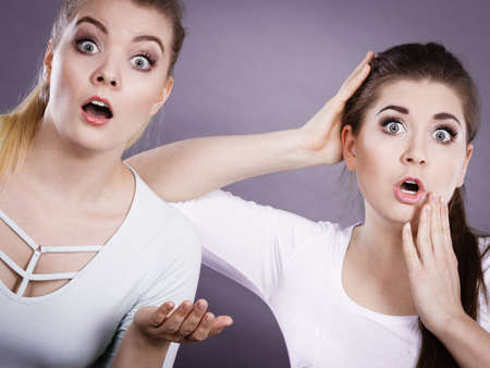 Shock face expressions concept. Closeup of two shocked and amazed women seeing something weird.の写真素材