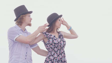 Vintage retro couple, man and woman enjoying their romantic date outside wearing fedora hats by seasideの写真素材