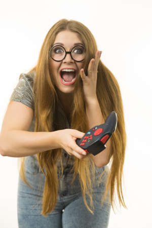 Young adult woman playing on the video console holding game pad. Gaming gamers concept.の写真素材
