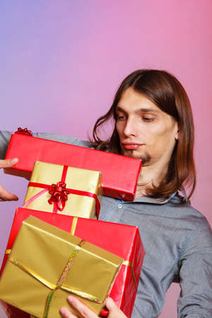 Holiday, xmas winter time season and special occasion. Young handsome stylish man holding a lot of presents gifts boxesの写真素材