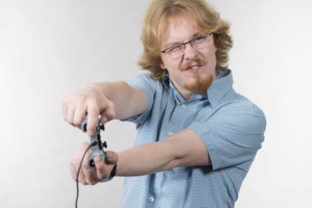 Nerd geek young adult man playing on the video console holding game pad. Gaming gamers concept.
