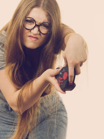 Young emotional adult woman playing on the video console holding pad being very into game. Gaming...