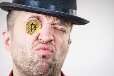 Adult man having bitcoin coin as pince nez in eye. Crypto internet currency banking concept.