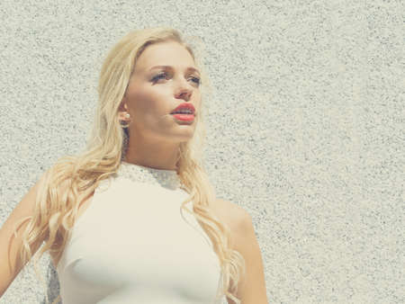 Stunningly beautiful elegant fashionable blonde woman outdoor. Female wearing white crop top during...