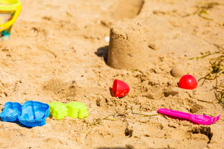 Summer kids toys on sandy beach druing summertime. Fun accessories objects concept.の写真素材