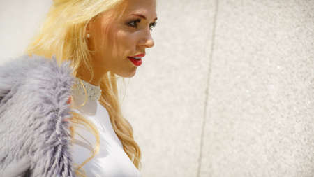 Glamurous female fashion model presenting casual elegant outfit. Woman wearing crop top and holding...
