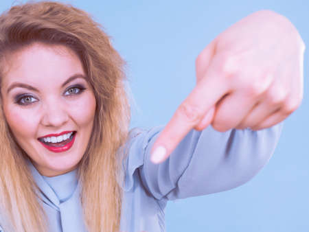 Happy joyful blonde woman with cruly hair pointing with finger at herselfの写真素材