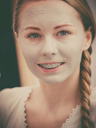 Skincare. Young positive woman with grey clay mud mask on her face.の写真素材