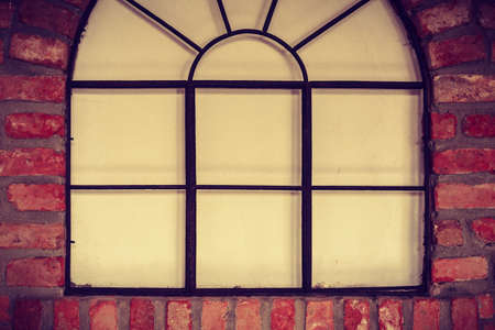 Textures and close up detailed patterns concept. Big rounded window on red brick wall