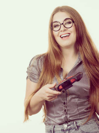 Young adult woman playing on the video console holding game pad. Gaming gamers concept.