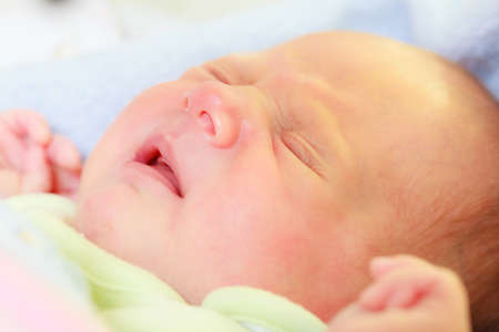 Infant care, beauty of childhood concept. Little newborn baby sleeping calmly in bed surrounded with...