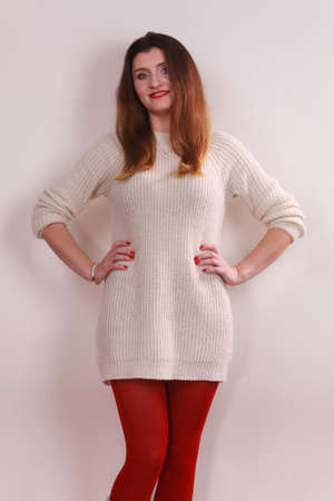 Portrait of young long hair female, woman wearing white sweater red warm pantyhose