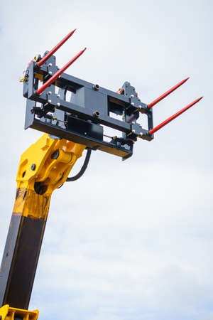 Forklift industrial loader object on sky background with white clouds. Haystack loading agricultural...