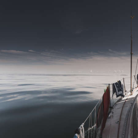 Yachting on sail boat during sunny summer weather on calm blue sea water. Sporty transportation...