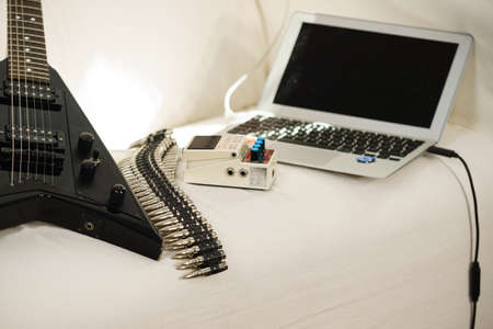 Modern audio production. Set up for indoor music studio at home. Electric guitar with effects and...