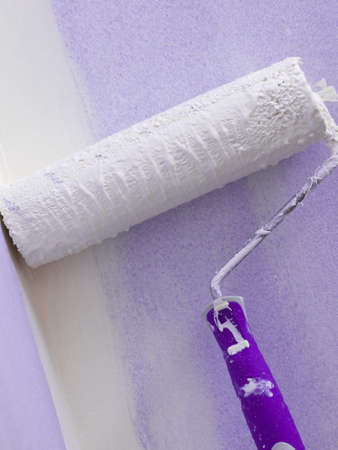Person appplying paint on wall using roller brush. Home renovation concept.の写真素材