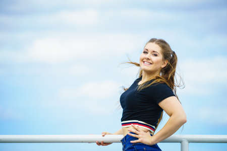 Happy joyful smiling woman spending her free time outside enjoying beautiful summertime weather.