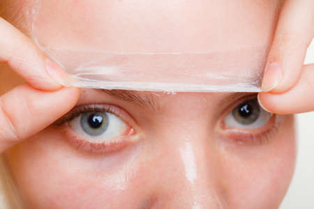 Beauty skin care cosmetics and health concept. Young woman part of face, girl removing facial peel off mask. Peeling.の写真素材
