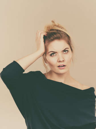 Confused young blonde woman thinking and trying to figure out problem solution.