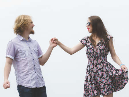 Joyful couple having fun outdoor. Young man and woman holding hands together during date.の写真素材