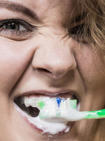 Woman brushing cleaning teeth. Positive girl with toothbrush. Oral hygiene.の写真素材