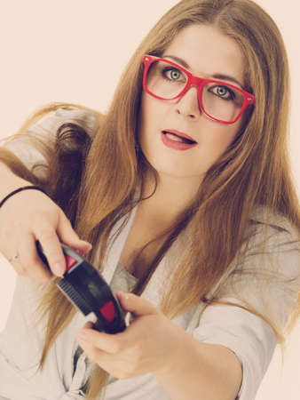 Young adult woman playing on the video console holding game pad. Gaming gamers concept.の写真素材