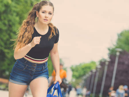 Woman wearing jeans denim shorts running somewhere in town being late during summer weather.の写真素材