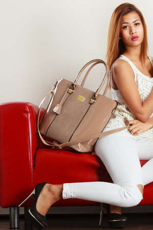 Fashion, clothes, clothing accessories, trendy outfits concept. Woman wearing light outfit and black...