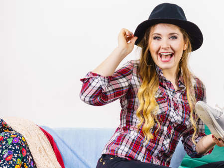 Happy funny joyful young woman in hat being positive after shopping on sales looking what she bought.の写真素材