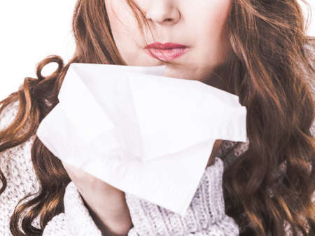 Sick freezing woman sneezing in tissue. Girl wearing warm sweater being cold and trembling. Flu or other virus. Health care.の写真素材