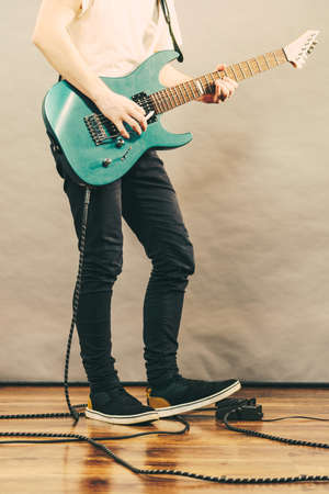 Unrecognizable teenage man playing on electric guitar indie rock. Musical instruments concept.