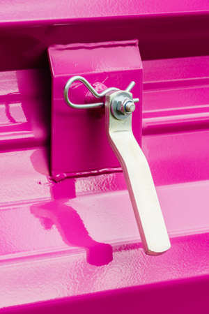 Construction machines concept. Detailed closeup of screw and bolts on pink indrustrial machineryの写真素材