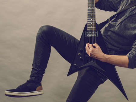 Man playing on electric guitar during gig. Musical instrument. Teenage boy having music hobby.の写真素材
