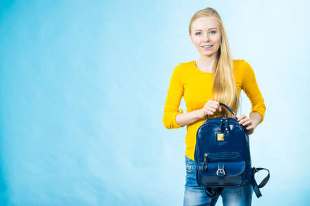 Blonde teenage girl going to school or college wearing stylish backpack. Outfit trendy accessories....